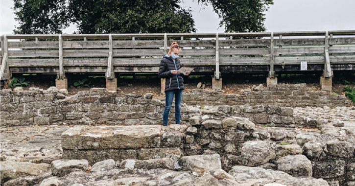 blogger Melissa stood reading a map with mask on at Binchester Roman Fort, Bishop Auckland